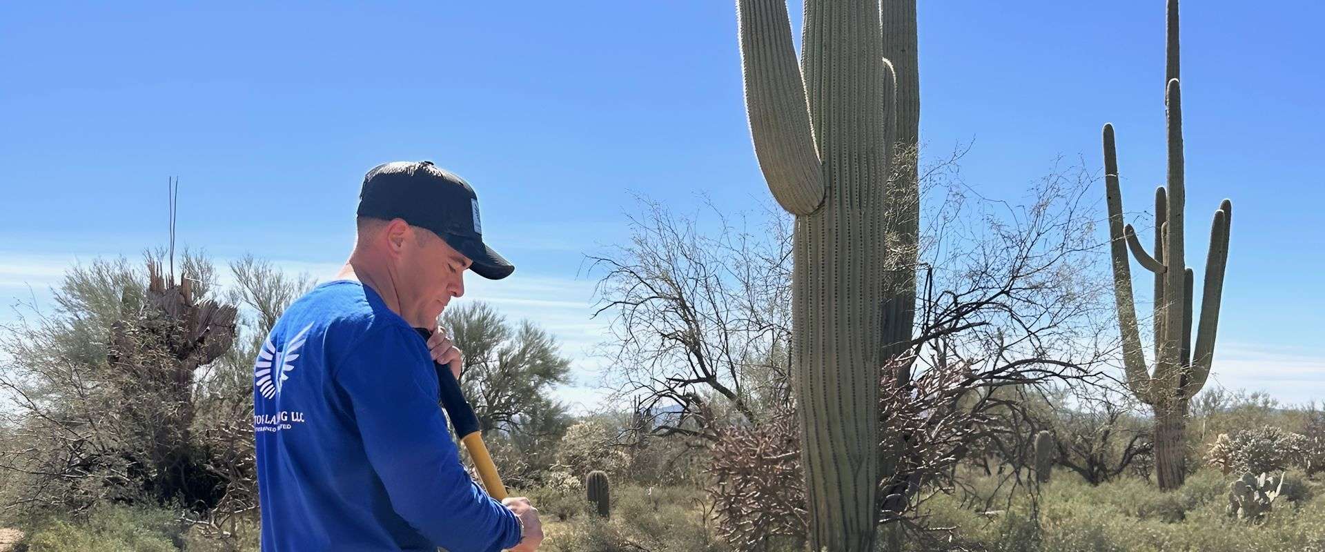 Wren Pest technician applying mosquito barrier treatment to backyard vegetation in Tucson