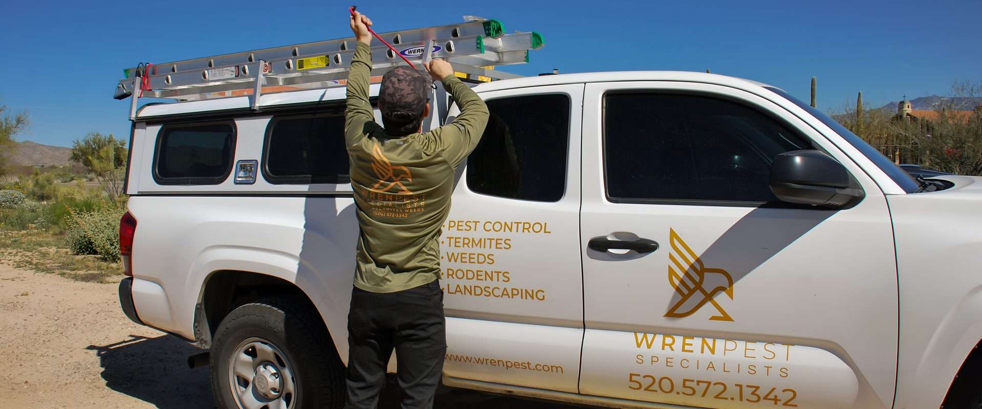 Wren Pest technician preparing ladder for rodent exclusion and roof access work in Tucson